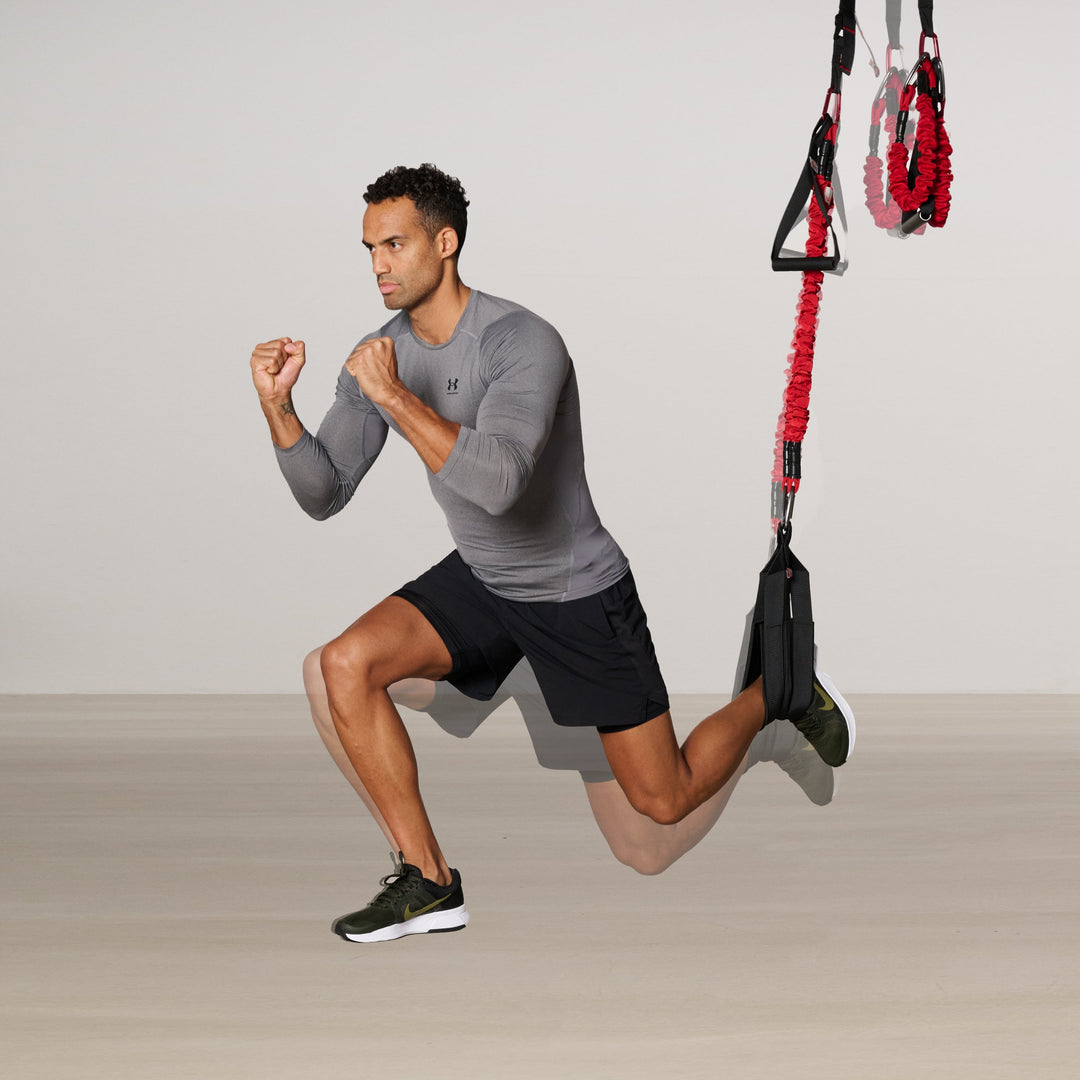 Man exercising with a 4D PRO® Bungee Trainer System trainer on a plain background